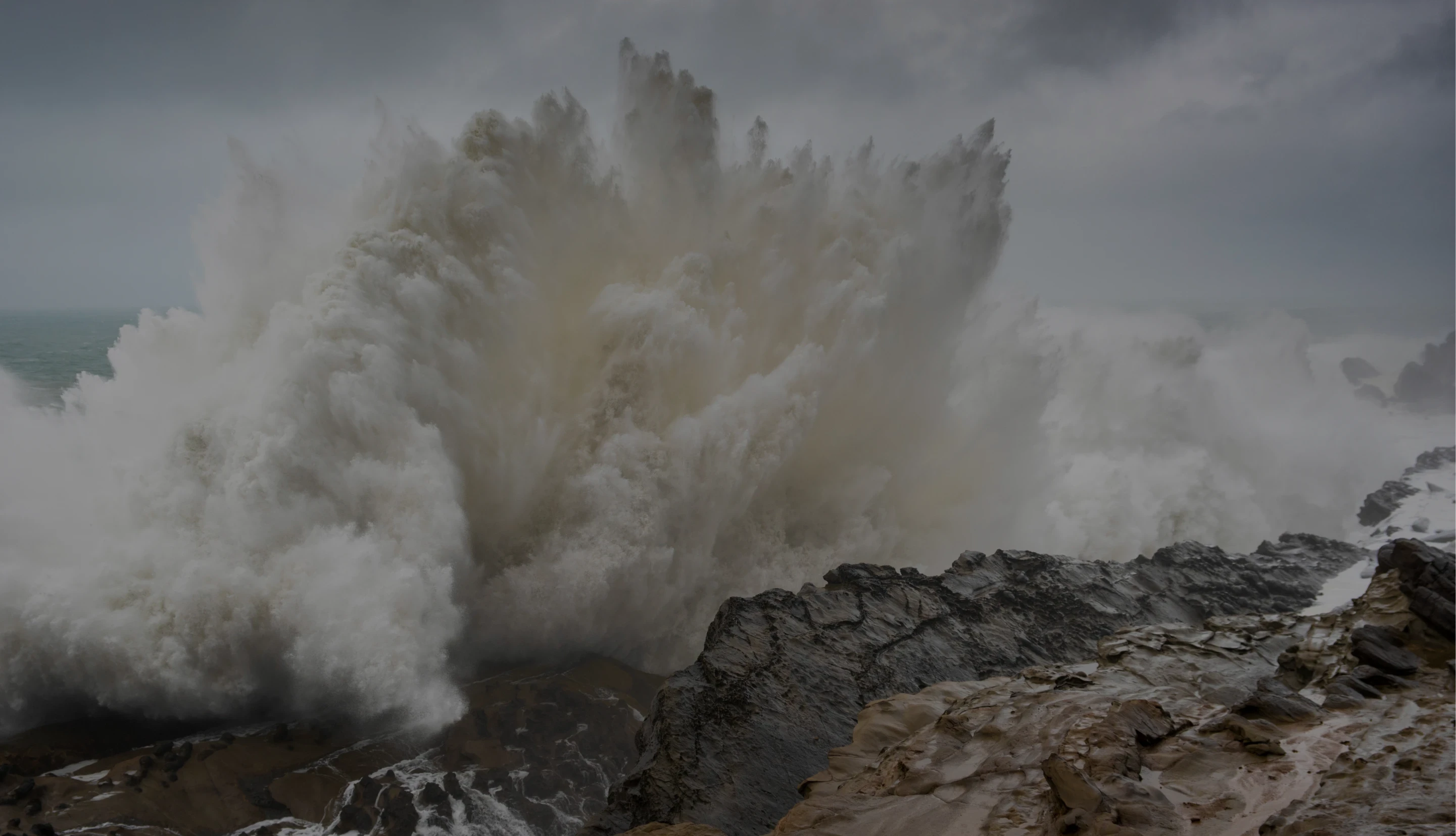 Wave crashing triumphantly against rocky shore.